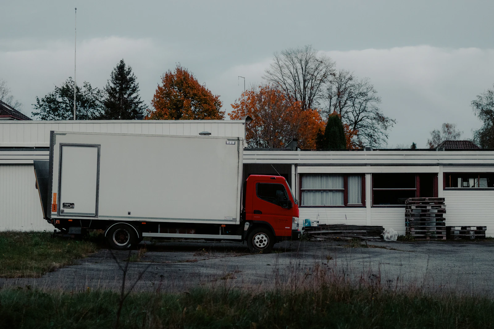 A straight truck parked alongside an industrial building.