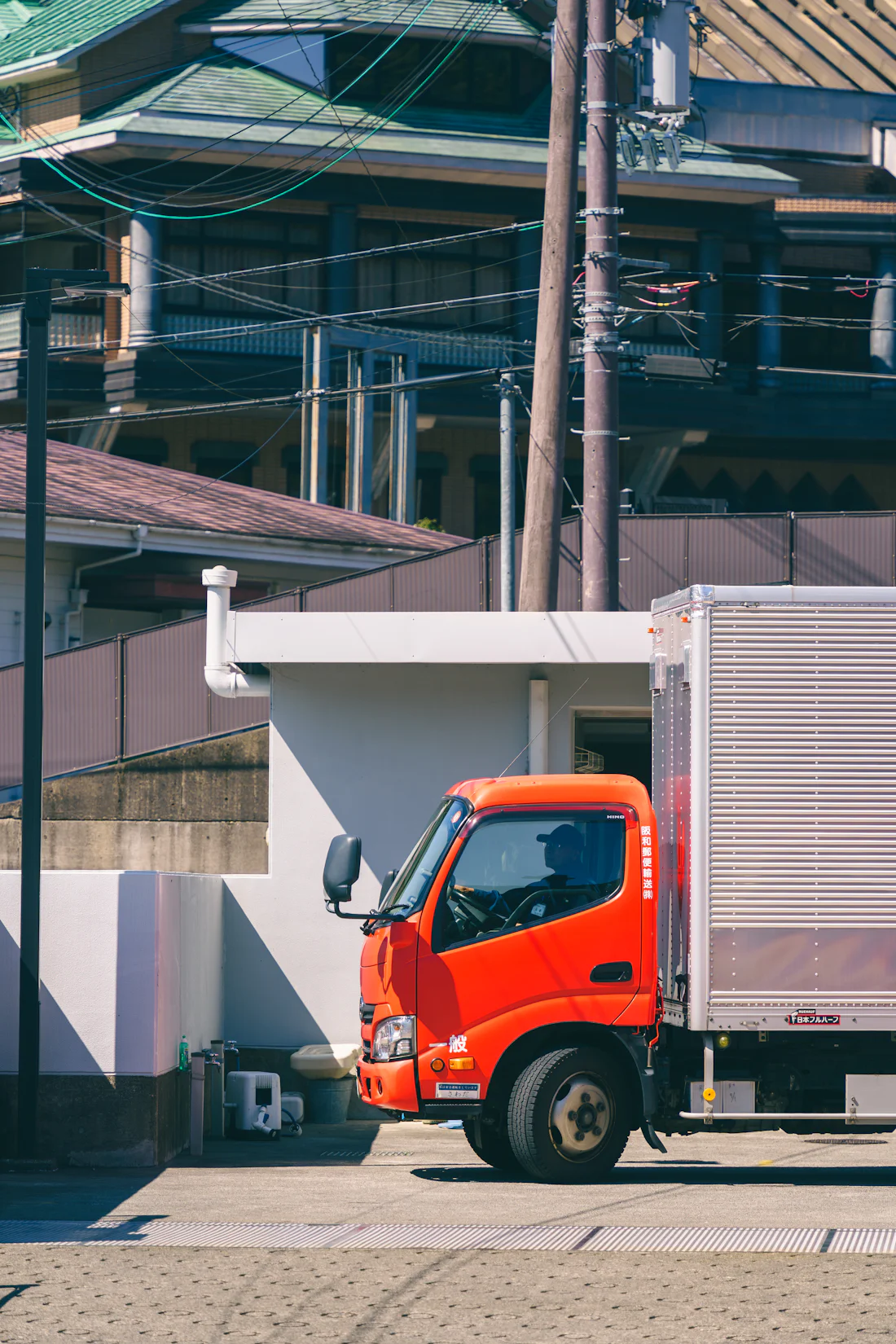 A box truck making a commercial delivery at a business address.